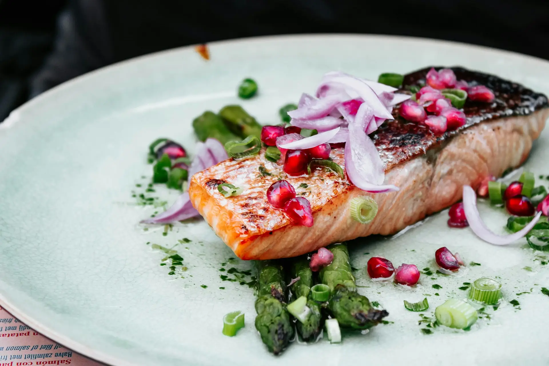 Salmon on a plate with onion and greens